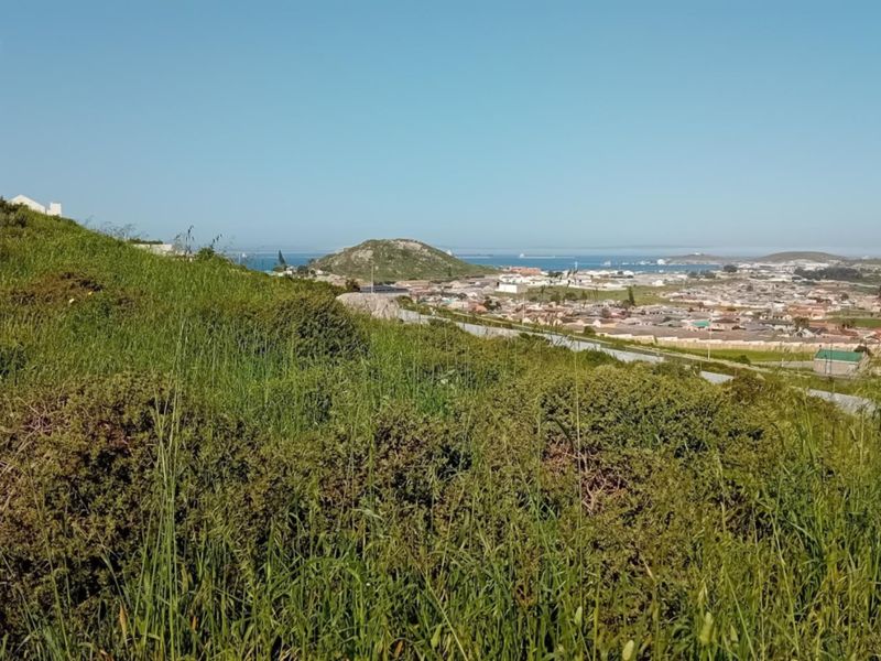 A scenic elevated view overlooking the surrounding residential neighborhood and distant coastline from the vacant land plot.