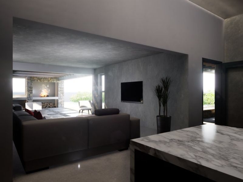 Modern open-plan living area featuring a marble kitchen island, stone fireplace, and contemporary concrete wall finishes with integrated lighting.
