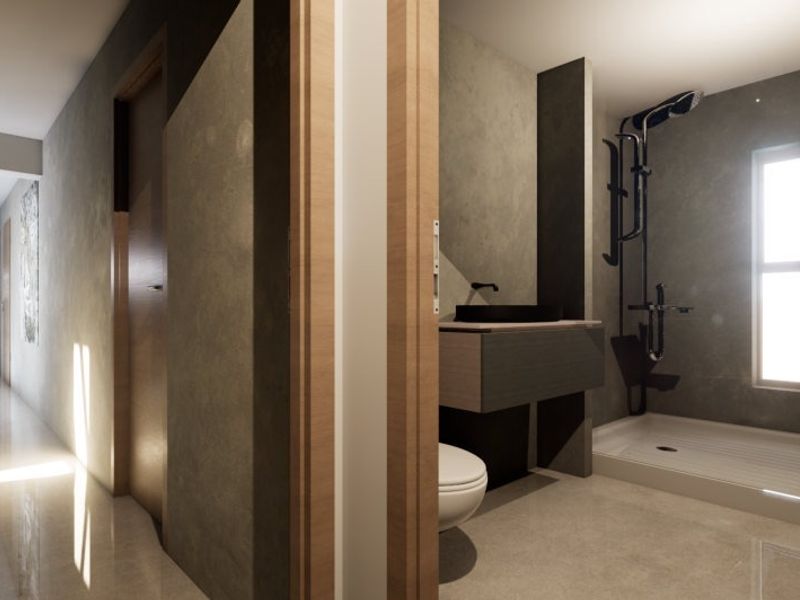A modern, minimalist bathroom featuring a walk-in shower, wall-mounted vanity with a vessel sink, and sleek grey finishes, viewed from an adjacent hallway.