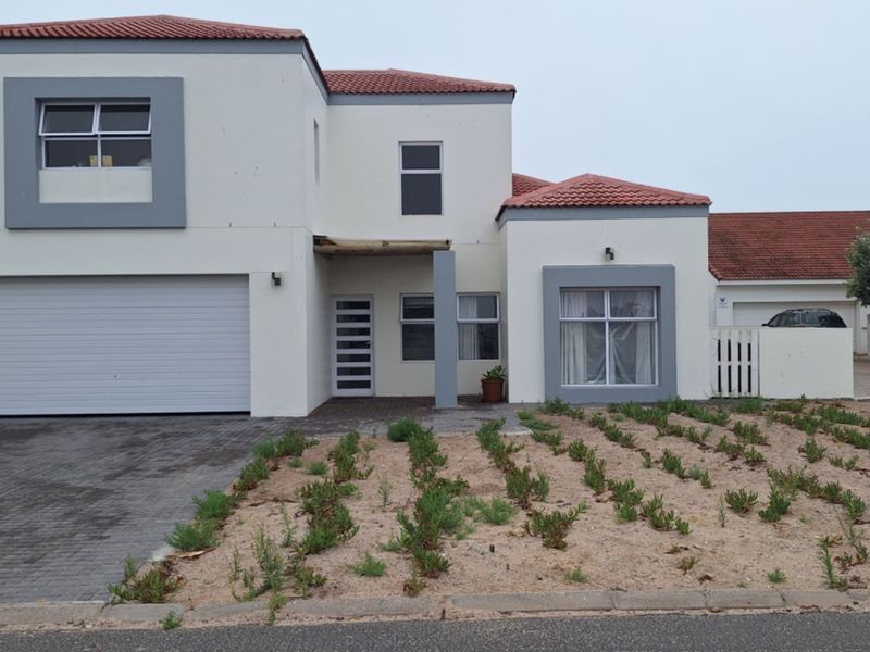A modern double-storey residential property featuring a paved driveway, integrated double garage, and a low-maintenance front garden area.