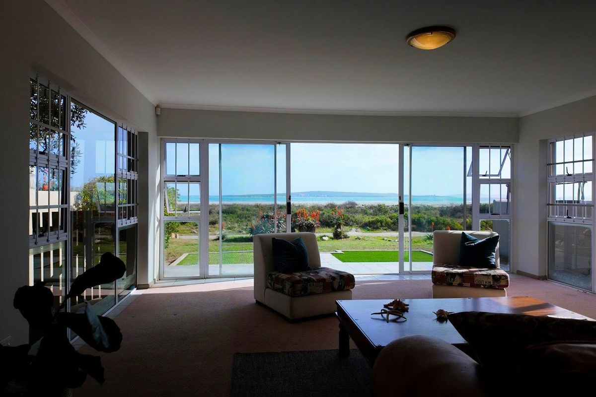 Spacious living room featuring large sliding glass doors that provide abundant natural light and direct views of the garden and ocean.