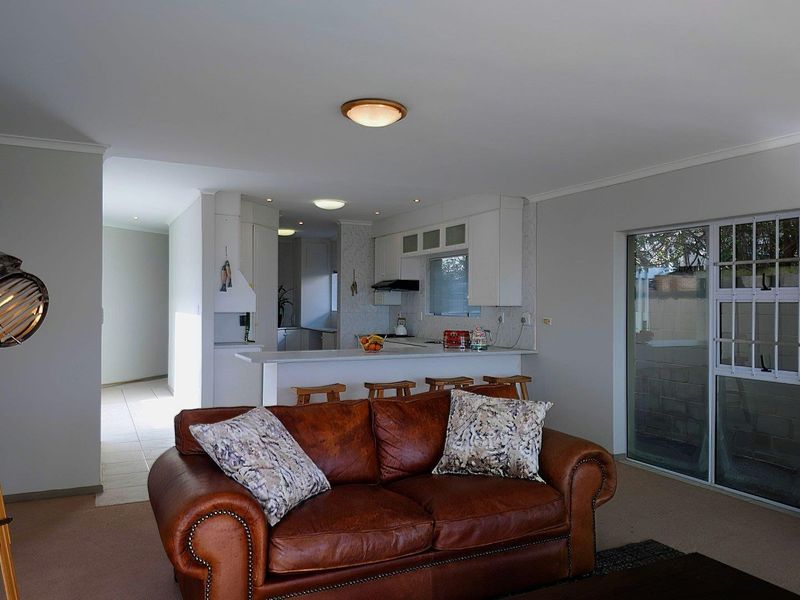 Open plan living area featuring a kitchen with breakfast bar and sliding glass doors leading to the exterior.