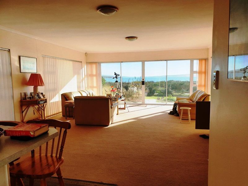 Spacious living room featuring large sliding glass doors that provide abundant natural light and expansive views of the surrounding landscape.
