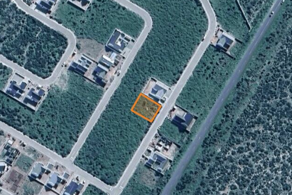 Aerial view of a vacant residential land plot highlighted within a developed suburban estate.