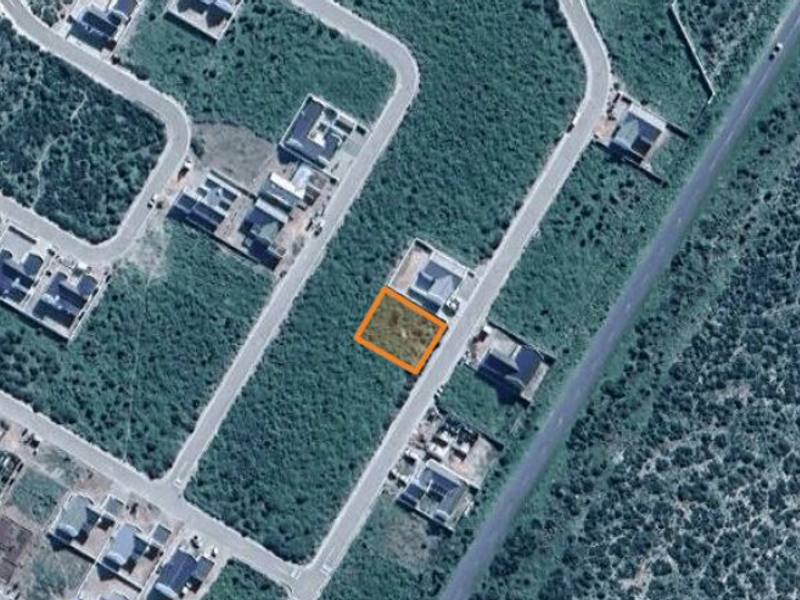 Aerial view of a vacant residential land plot highlighted within a developed suburban estate.