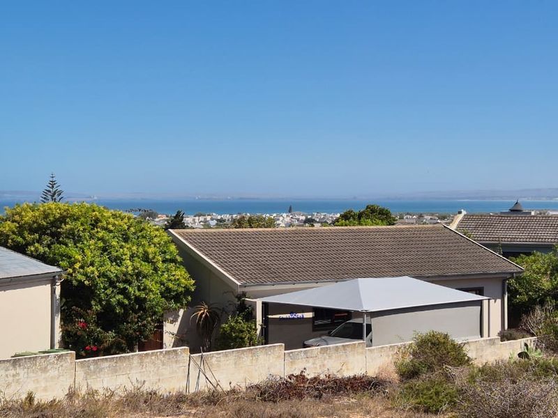 A scenic elevated view overlooking a coastal residential neighborhood and the ocean horizon.
