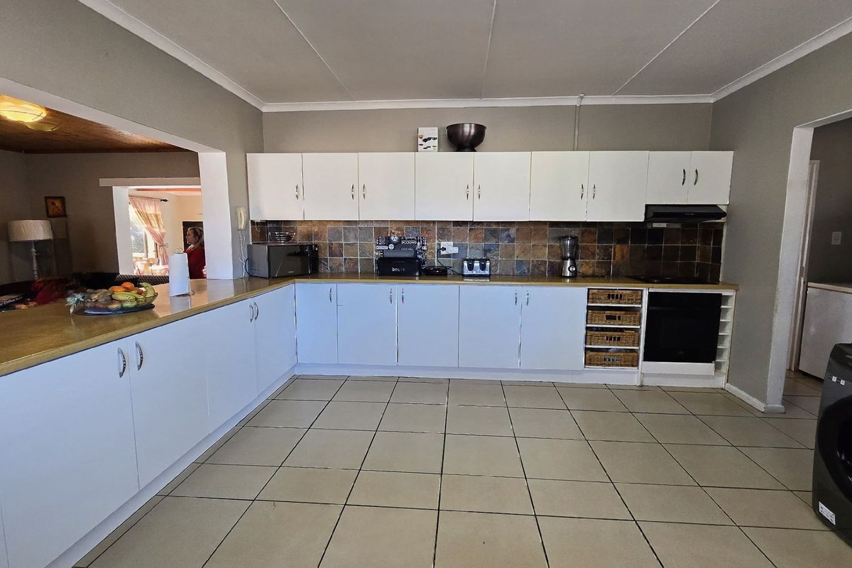 A functional kitchen featuring white cabinetry, a tiled backsplash, laminate countertops, and a built-in oven with an extractor fan.