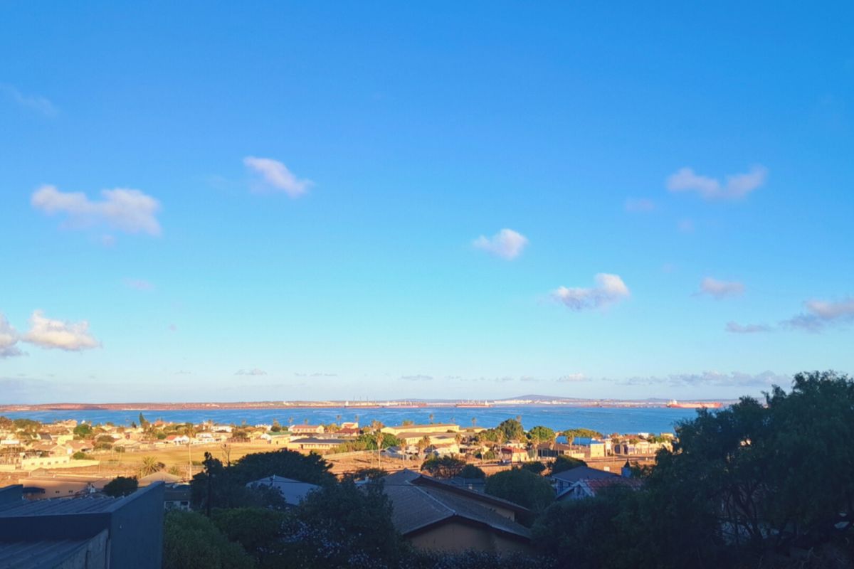 A scenic elevated view overlooking the coastal landscape, residential area, and the ocean horizon.