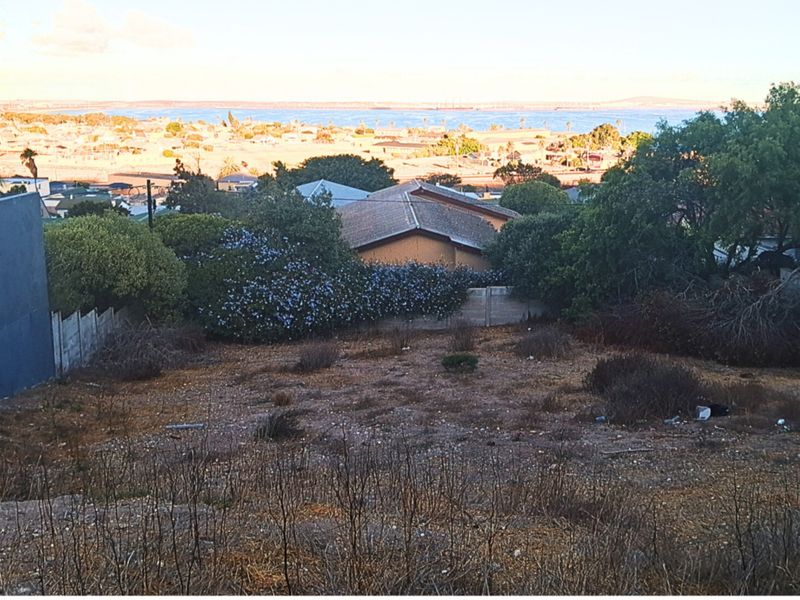 Elevated view overlooking the residential area and coastline, showcasing the potential of this vacant land plot.