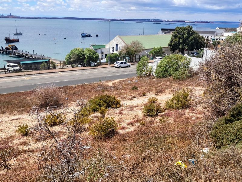 Elevated view overlooking the coastal bay, harbour area, and surrounding landscape from the vacant residential land.