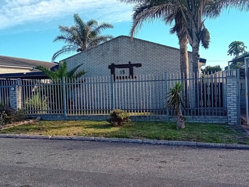 Front exterior view of the property featuring a brick facade, steel palisade fencing, and a paved driveway.