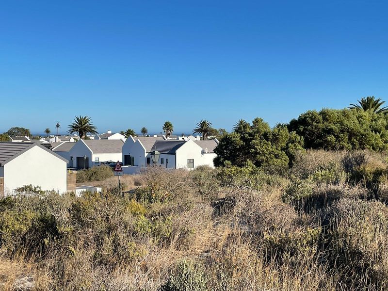 A view of the surrounding residential neighborhood and natural landscape from the vacant land plot.