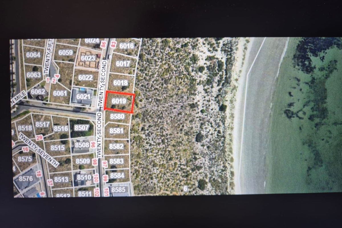 An aerial map view highlighting a specific residential vacant land plot within a coastal subdivision.