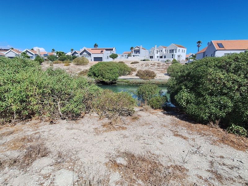 A view of a natural waterway and surrounding coastal landscape with residential properties visible in the background.