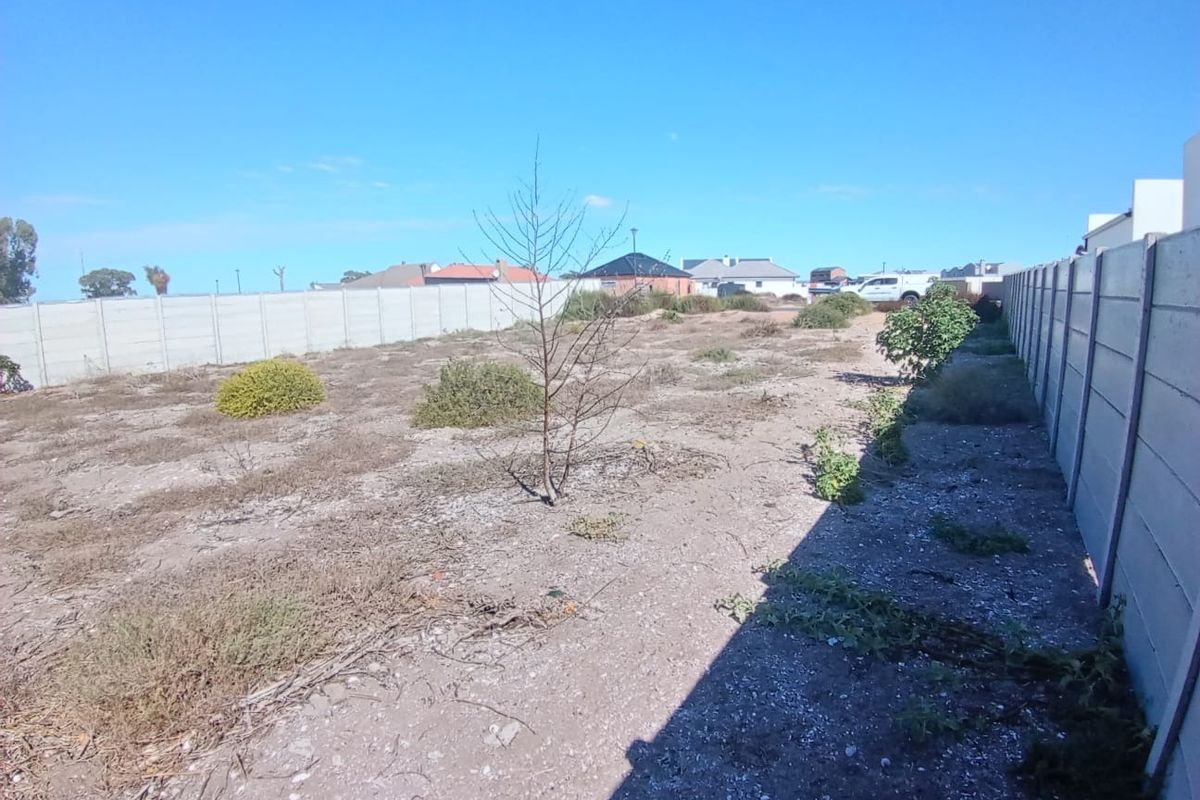 A vacant residential plot featuring a level surface enclosed by precast concrete boundary walls, ready for development.