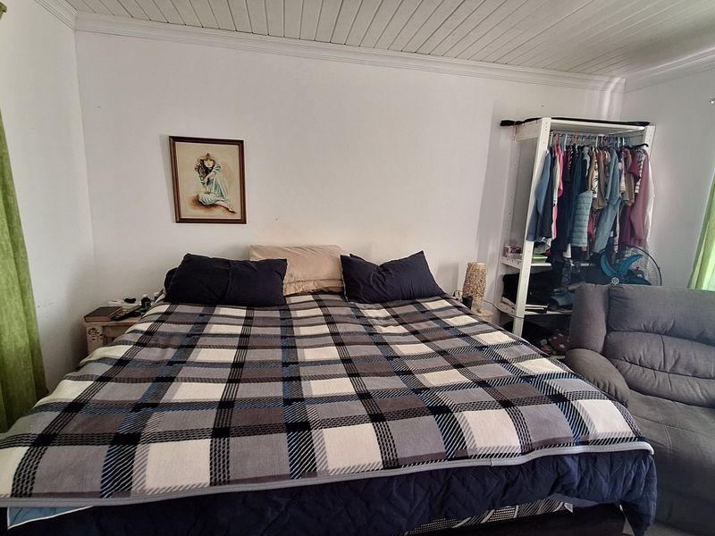 A bedroom featuring a white tongue and groove ceiling with crown molding, providing a neutral base for potential interior updates.