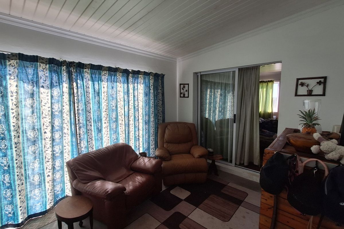 A living room featuring a sliding glass door leading to an adjacent space, finished with a white tongue and groove ceiling.
