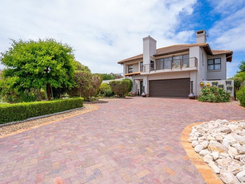 A well-maintained double-story residential property featuring a paved driveway, double garage, and an upper-level balcony with a tiled roof.