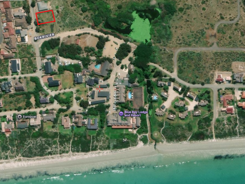 Aerial view showing the vacant residential plot highlighted in red, situated within a coastal estate near the beach and resort facilities.