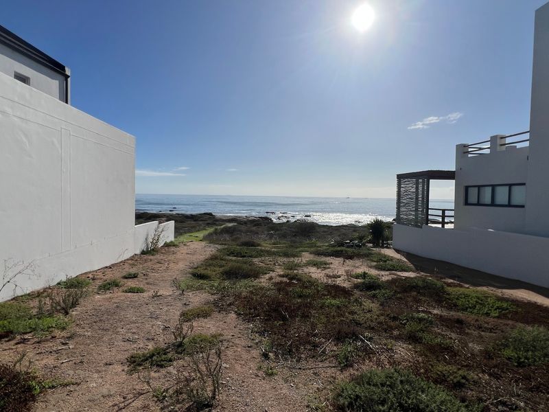 A scenic view of the coastline and ocean, framed by the adjacent residential structures.