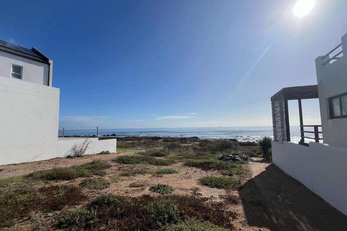 A scenic view of the ocean from the property, showcasing the coastal landscape and surrounding residential structures.