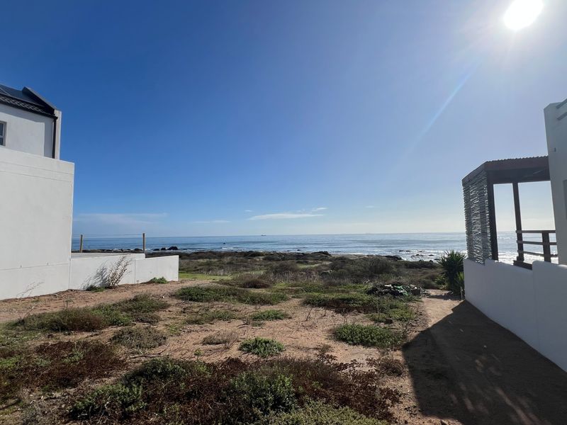 A scenic view of the ocean from the property, showcasing the coastal landscape and surrounding residential structures.