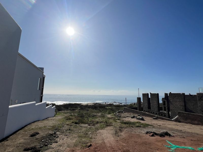 A wide-angle view of the ocean and coastal landscape from the residential property site.