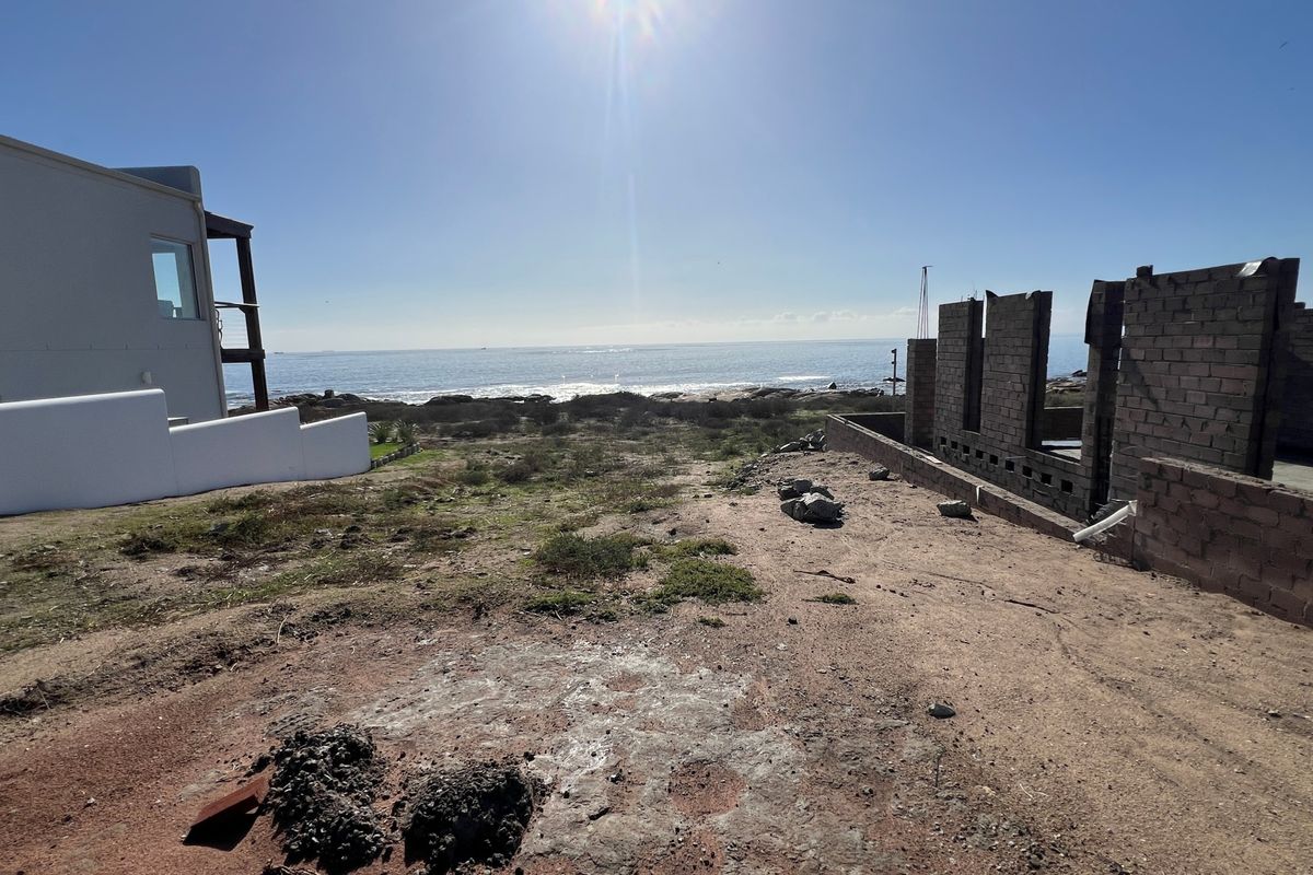 Vacant residential land featuring an ocean view and partially constructed masonry walls, offering a prime opportunity for development in a coastal setting.