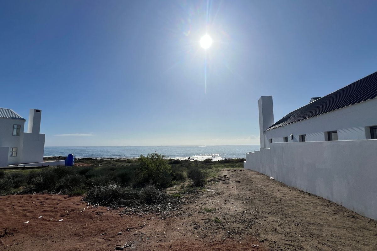 A scenic view of the ocean from the property, showcasing the coastal landscape and surrounding residential structures.