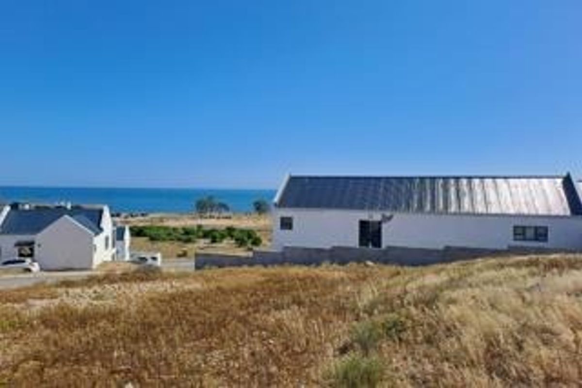A scenic view of the coastal landscape featuring nearby residential properties and an expansive ocean horizon.