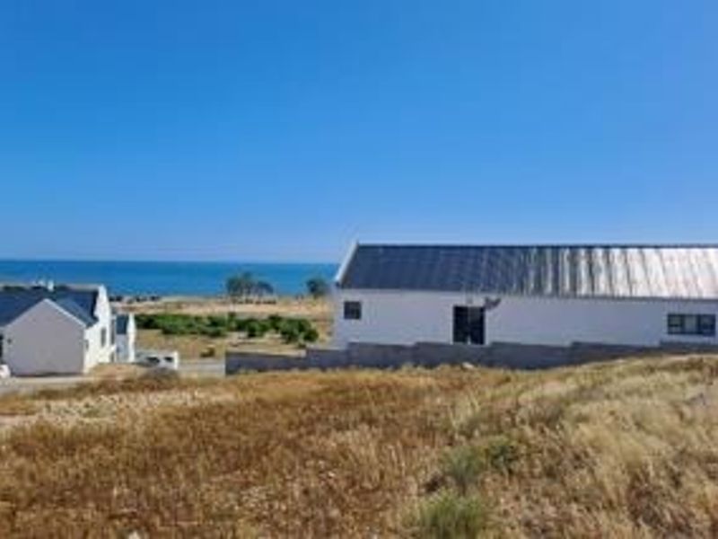 A scenic view of the coastal landscape featuring nearby residential properties and an expansive ocean horizon.