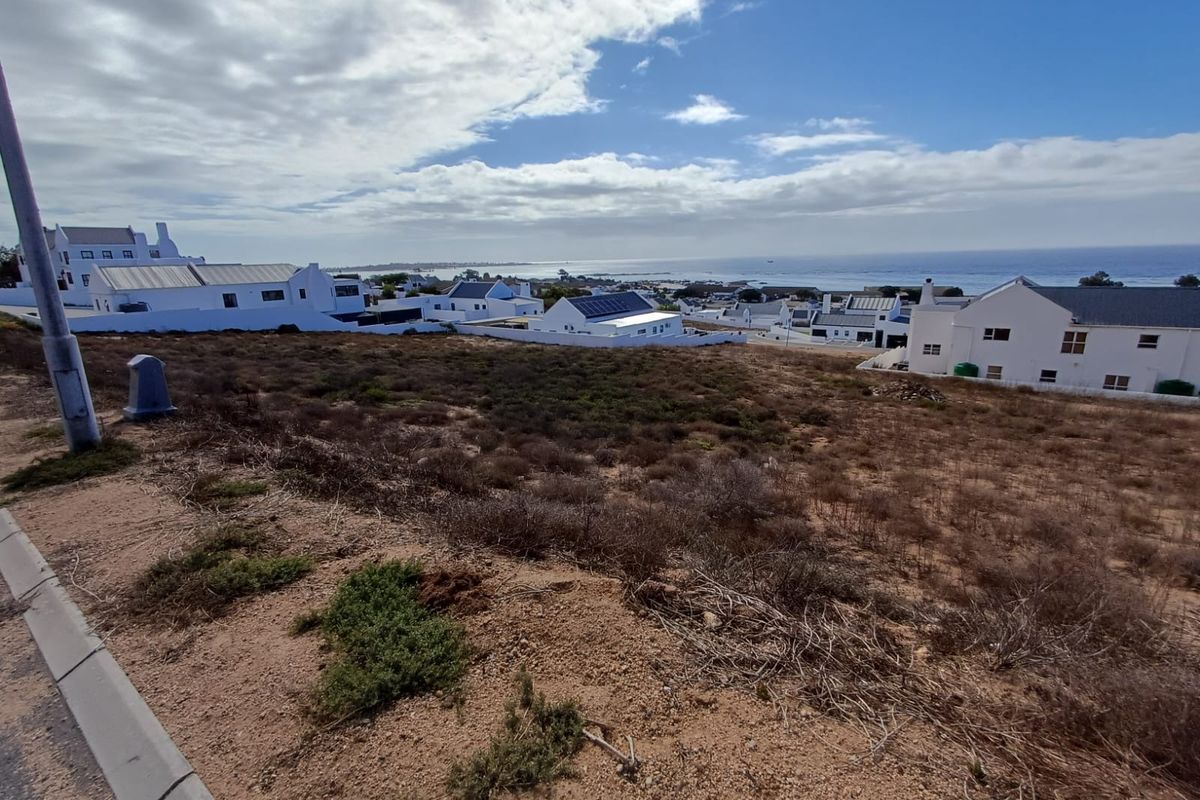 A view of the vacant residential land with a coastal outlook and surrounding established homes.