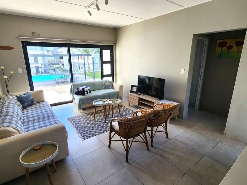 Open-plan living area featuring large sliding glass doors that provide natural light and direct access to the outdoor pool area.