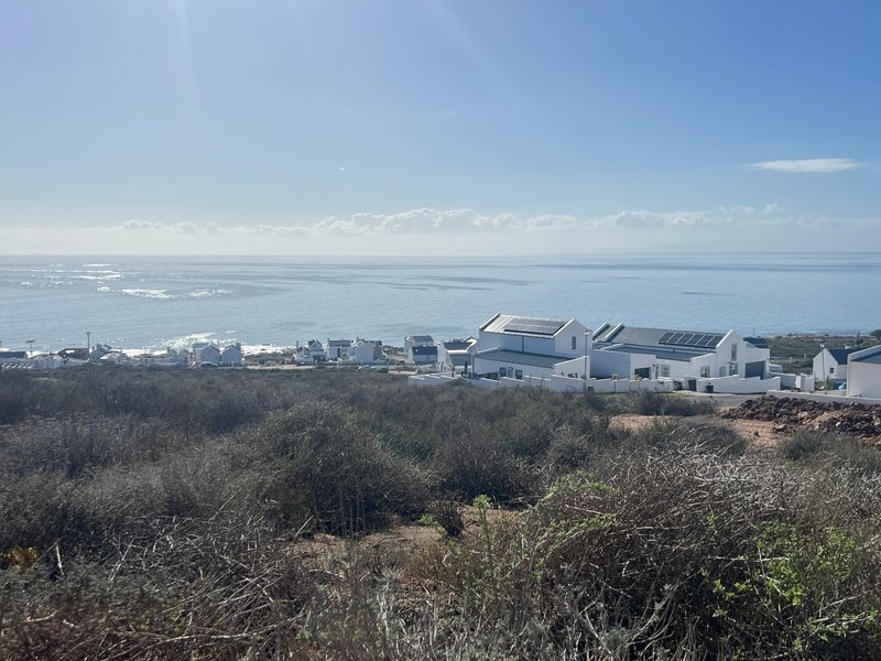A scenic elevated view overlooking the coastal landscape and ocean, showcasing the surrounding residential area and natural terrain.