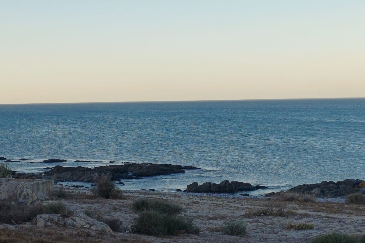 A scenic view of the ocean coastline featuring rocky outcrops and natural vegetation, highlighting the property's coastal location.