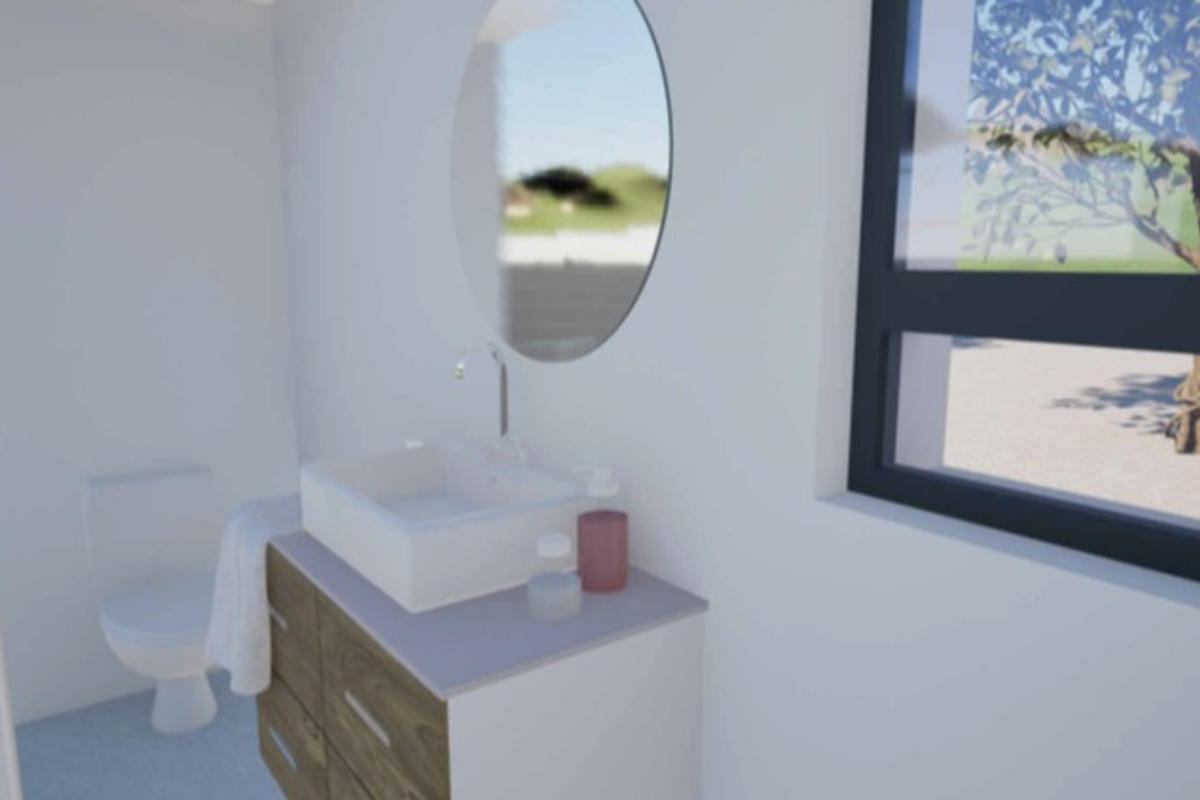 Modern bathroom featuring a wood-finish vanity with a vessel sink, round mirror, and toilet, illuminated by natural light from a large window.