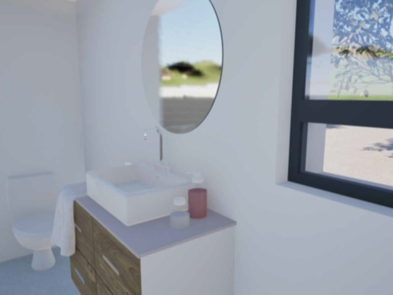 Modern bathroom featuring a wood-finish vanity with a vessel sink, round mirror, and toilet, illuminated by natural light from a large window.
