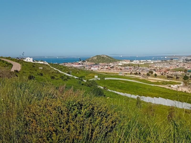 Elevated panoramic view overlooking the surrounding residential landscape, coastal area, and distant hills from the vacant land plot.