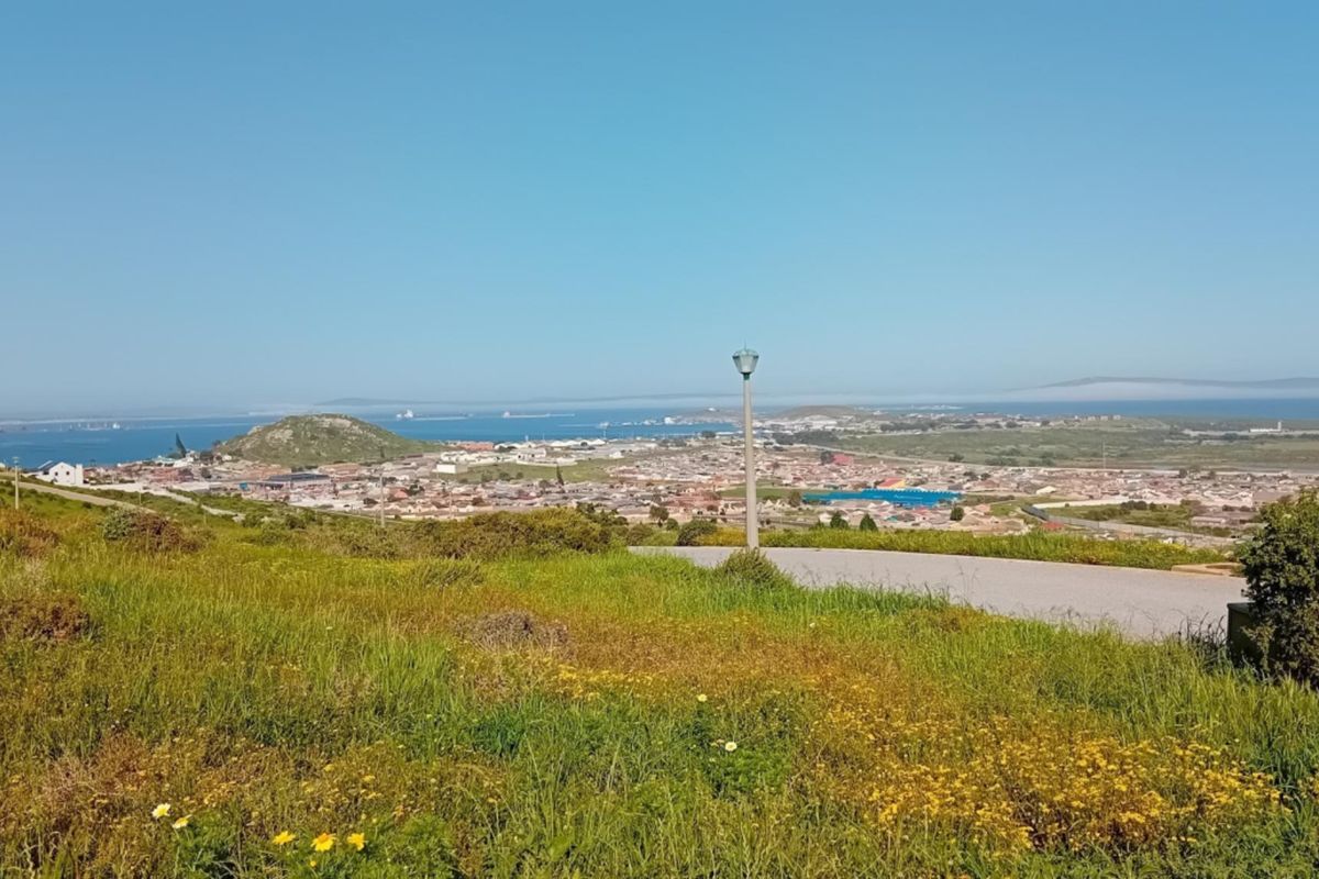A scenic elevated view overlooking the surrounding residential area, coastline, and ocean horizon from the vacant land plot.