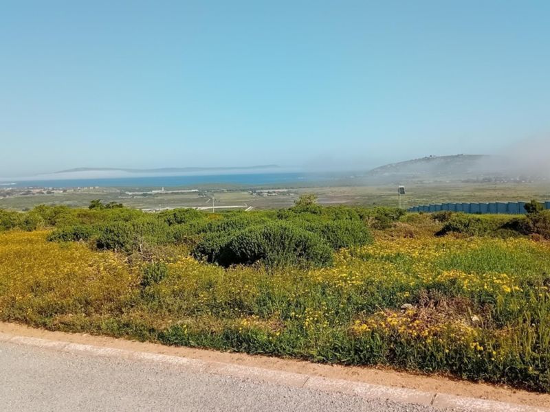 A scenic elevated view overlooking natural coastal landscape and distant ocean horizon from the vacant residential property.