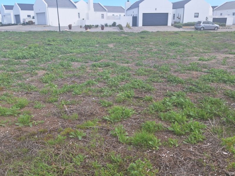 A vacant residential plot of land situated in a developed estate, ready for new construction.