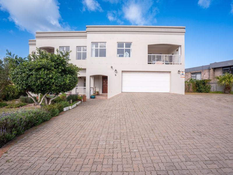 A well-maintained double-story residential property featuring a paved driveway, integrated double garage, and an upper-level balcony.