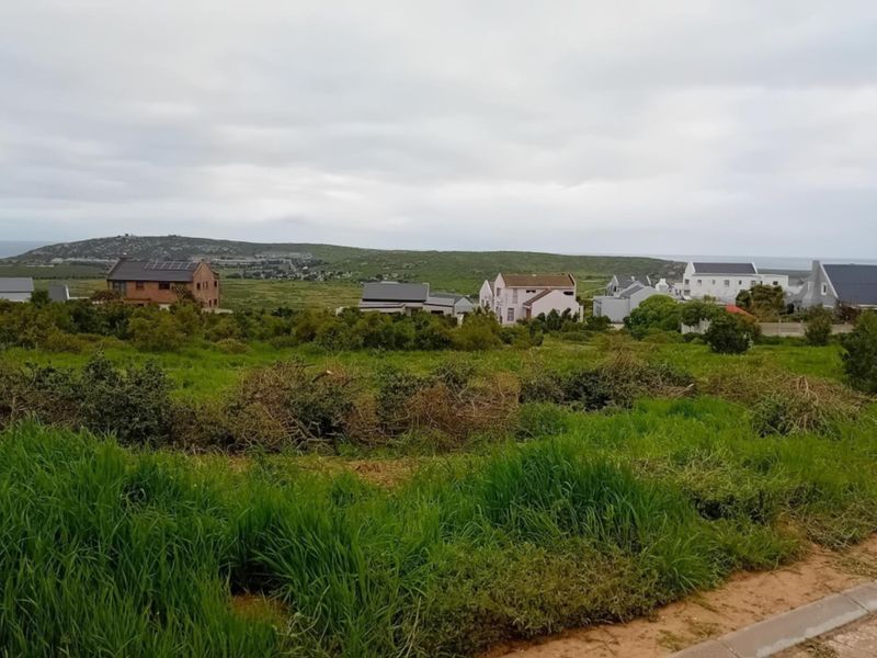 A scenic view overlooking a residential neighborhood and natural coastal landscape, showcasing the surrounding area and terrain.