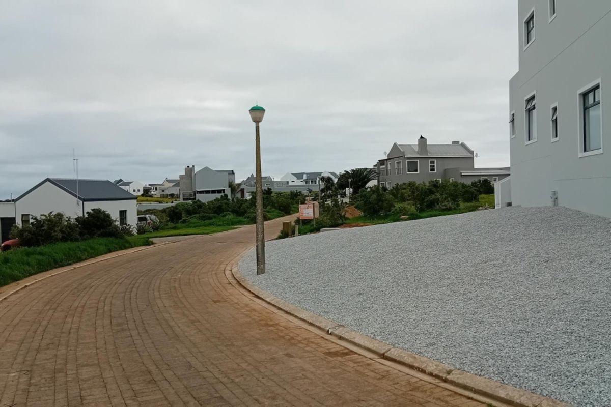 A view of the residential street showing paved road, gravel landscaping, and surrounding neighborhood properties.