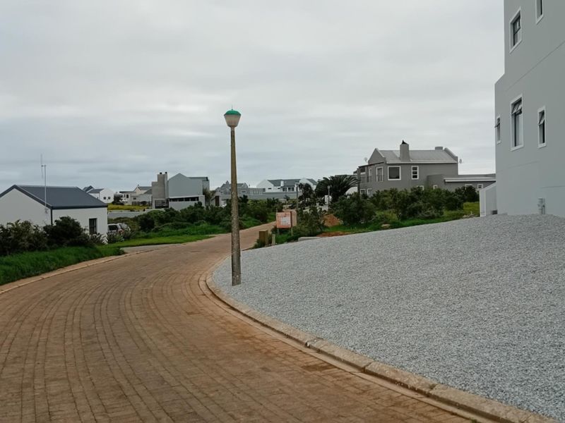A view of the residential street showing paved road, gravel landscaping, and surrounding neighborhood properties.