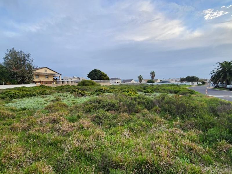 A vacant residential plot of land situated in a developed neighborhood with street access and boundary walling.