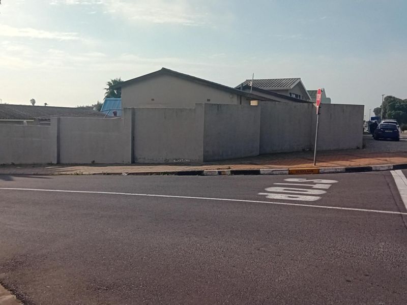 Street view showing the property's perimeter wall and corner location at a road intersection.