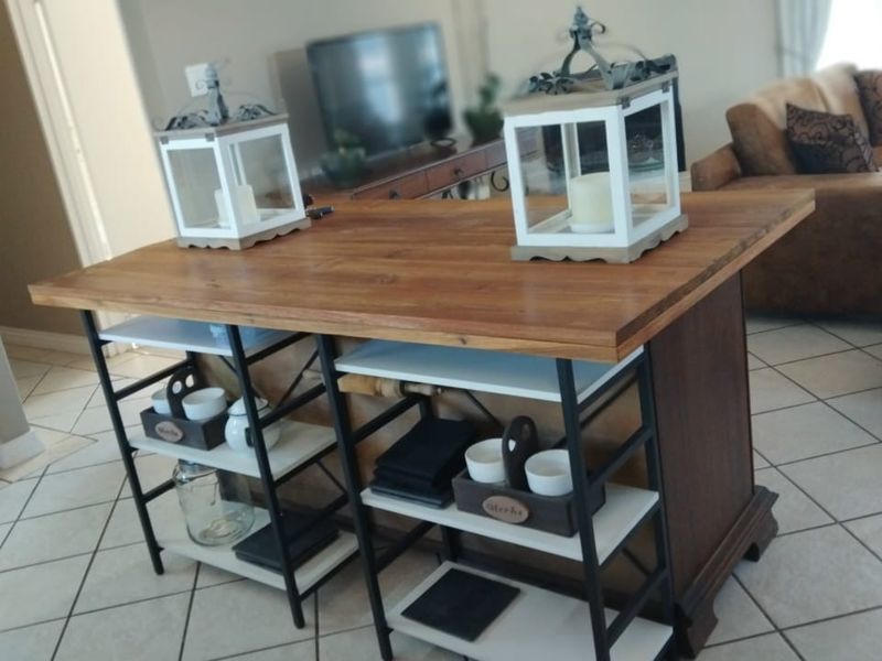 Open plan living area featuring tiled flooring and a central wooden kitchen island unit.