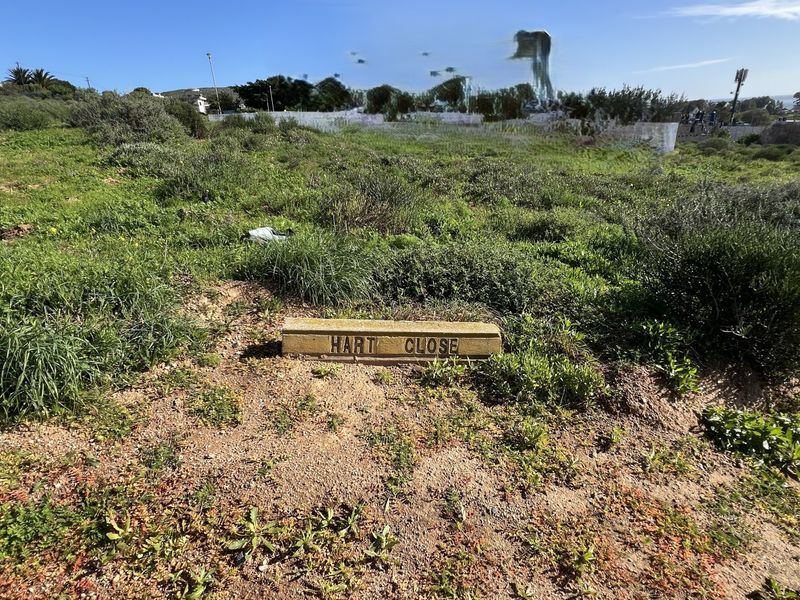 A view of the vacant residential land plot featuring a street name sign for Hart Close.