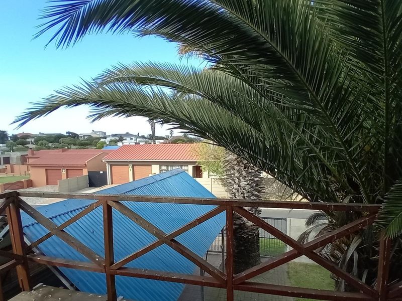 An elevated balcony featuring a wooden balustrade with views over the surrounding residential neighbourhood.